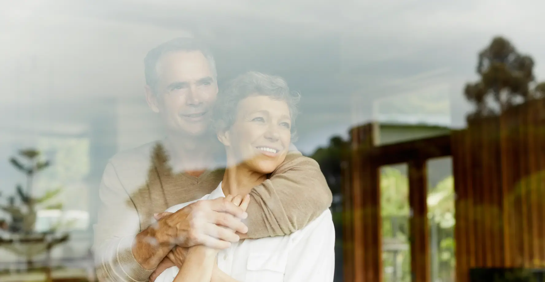 Älteres Ehepaar blickt zufrieden in die Natur