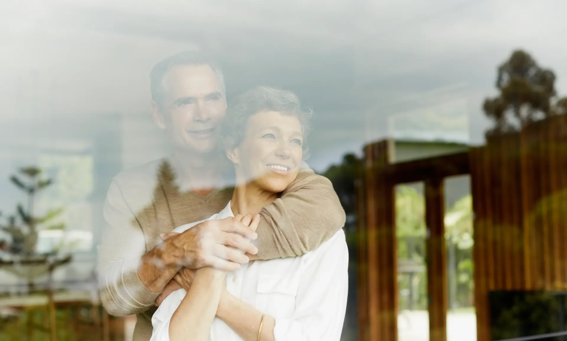 Älteres Ehepaar blickt zufrieden in die Natur