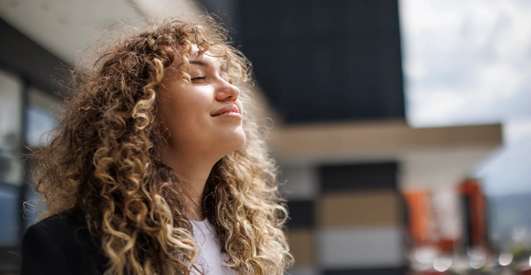 Frau blickt zufrieden der Sonne entgegen