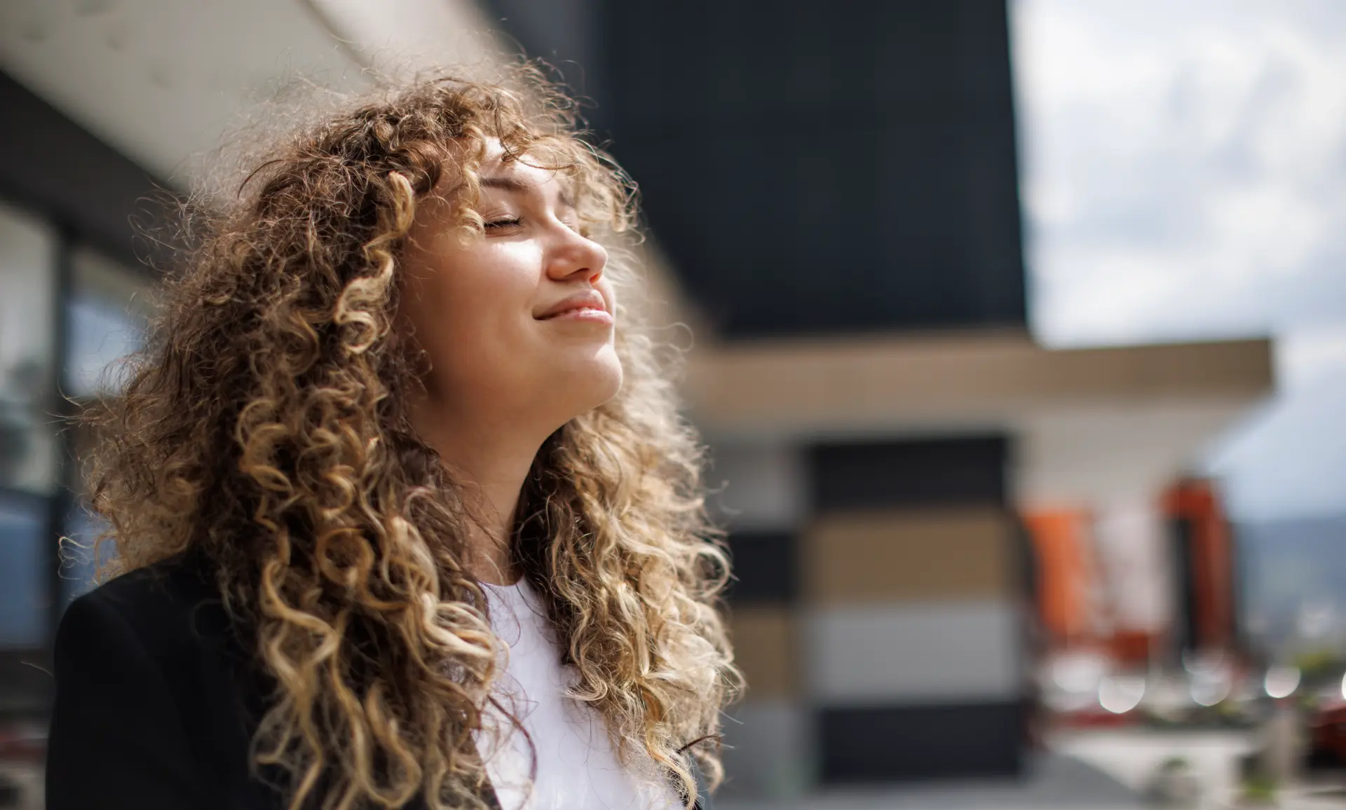 Frau blickt zufrieden der Sonne entgegen