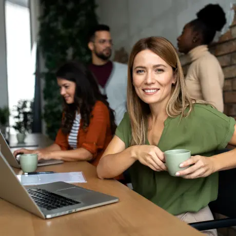 Eine Frau die sich bei der Arbeit am Laptop weiterbildet