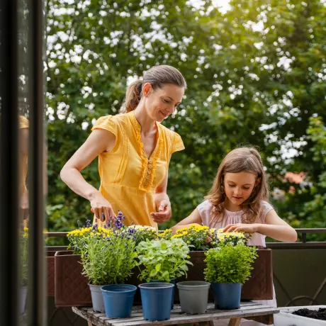 Mutter mit Tochter bei der Kräuterpflege
